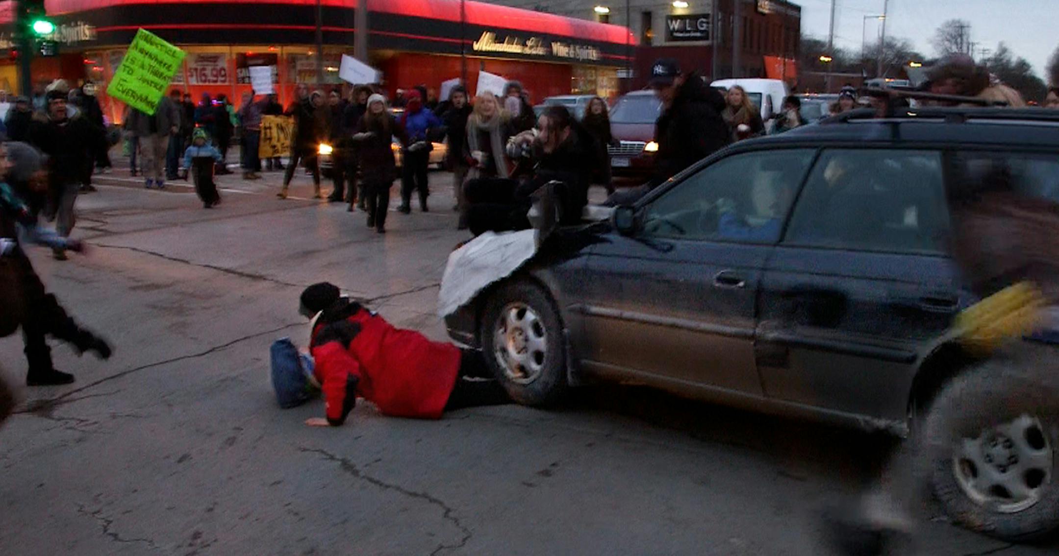 A car plows through a Ferguson rally in South Minneapolis after protesters blocked the intersection of Lake Street and Minnehaha Avenue on Tuesday, Nov. 25, 2014, during a rally in the wake of the grand jury decision not to indict officer Darren Wilson in the shooting death of Ferguson, Mo., teen Michael Brown. (Mark Vancleave/Minneapolis Star Tribune/TNS) ORG XMIT: 1160543 ORG XMIT: MIN1411251913051501
