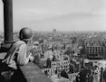 An American lieutenant looks out over the German city of Leipzig from an observation platform on the spire of the cathedral. All buildings within rang