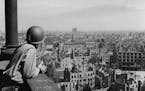 An American lieutenant looks out over the German city of Leipzig from an observation platform on the spire of the cathedral. All buildings within rang