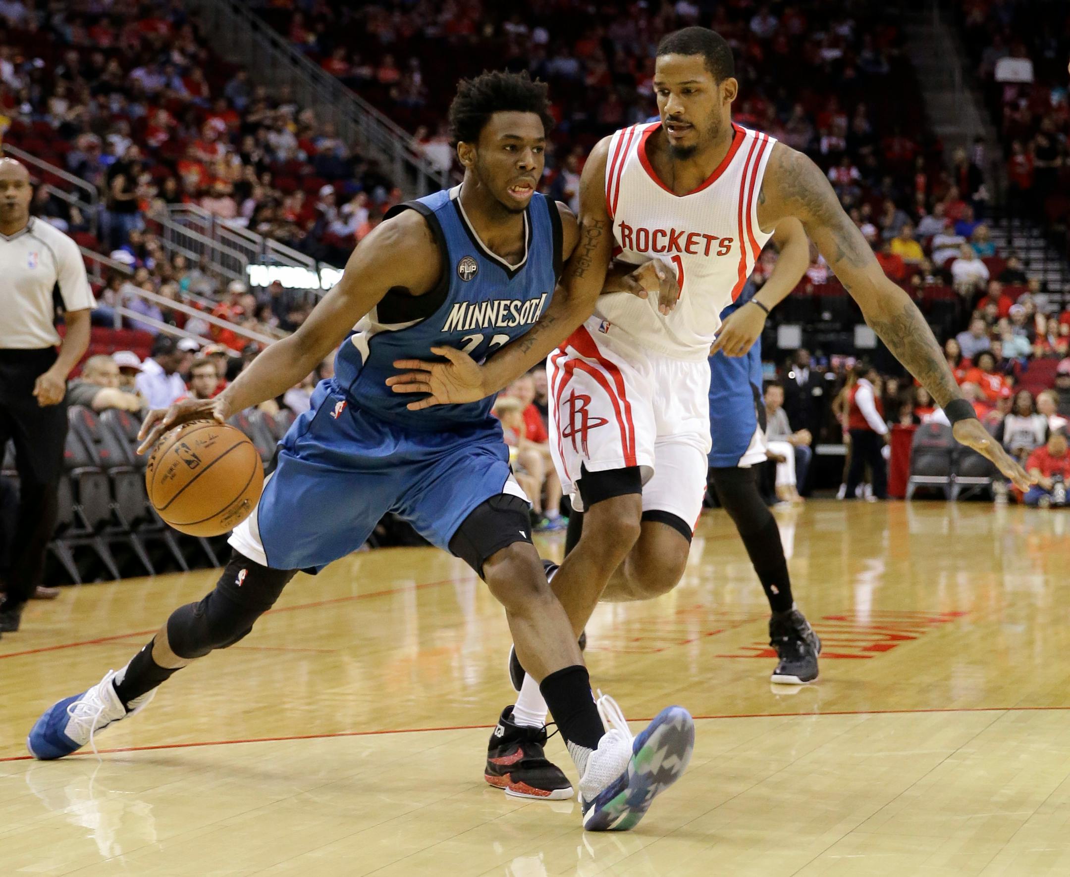 Minnesota Timberwolves' Andrew Wiggins, left, drives toward the basket as Houston Rockets' Trevor Ariza (1) defends during the first half of an NBA basketball game Friday, March 18, 2016, in Houston. (AP Photo/David J. Phillip)