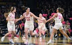 Iowa guard Caitlin Clark (22) celebrated a three-point basket with Iowa guards Molly Davis, left, and Gabbie Marshall, right, during the first half ag