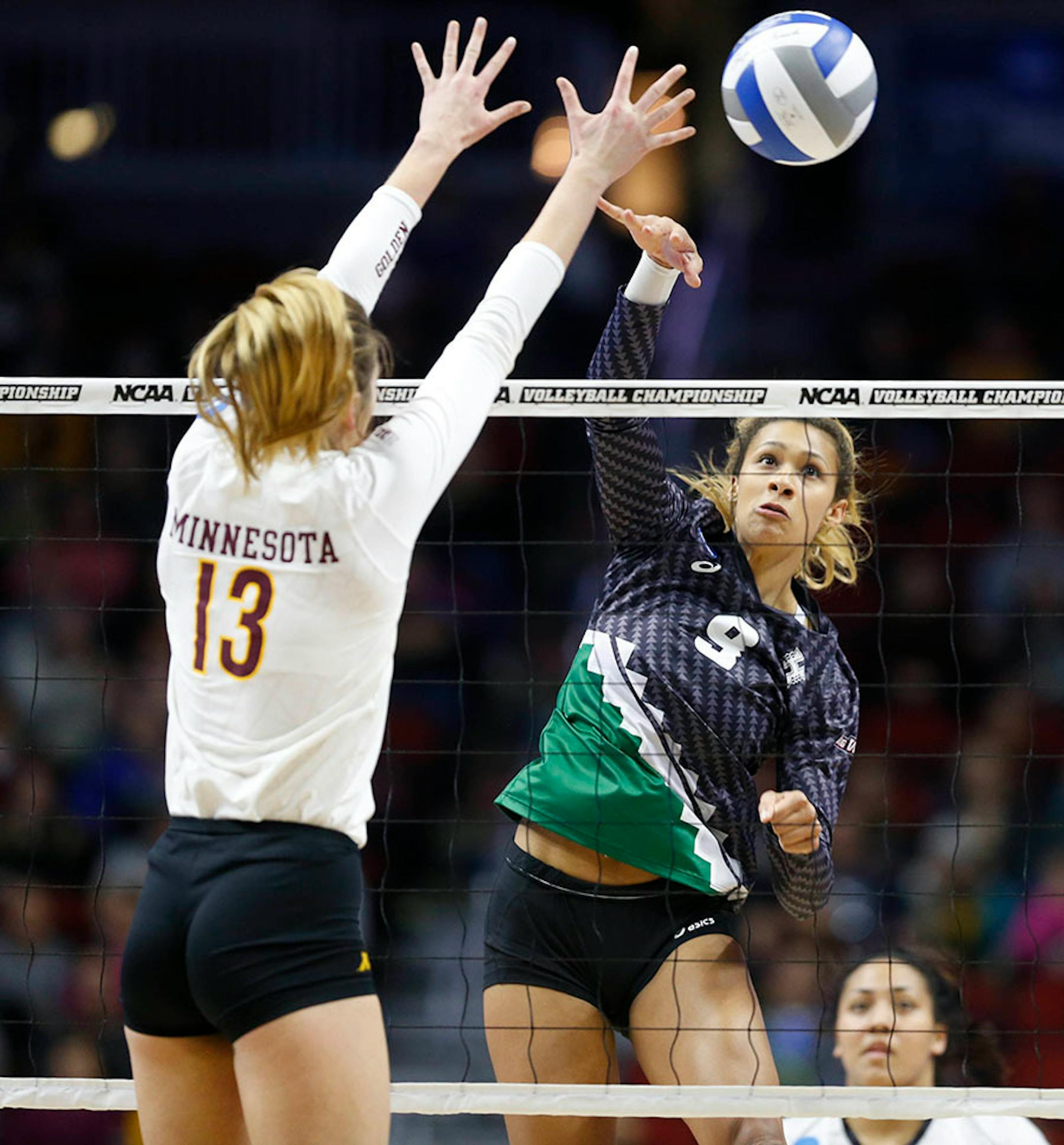 Hawaii's Olivia Magill (9) spikes the ball past Minnesota's Molly Lohman (13) Saturday, Dec. 12, 2015, during the NCAA Division I Women's Volleyball Championship in Des Moines, Iowa.