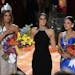 Former Miss Universe Paulina Vega, center, reacts before taking away the flowers, crown and sash from Miss Colombia Ariadna Gutierrez, left, before gi