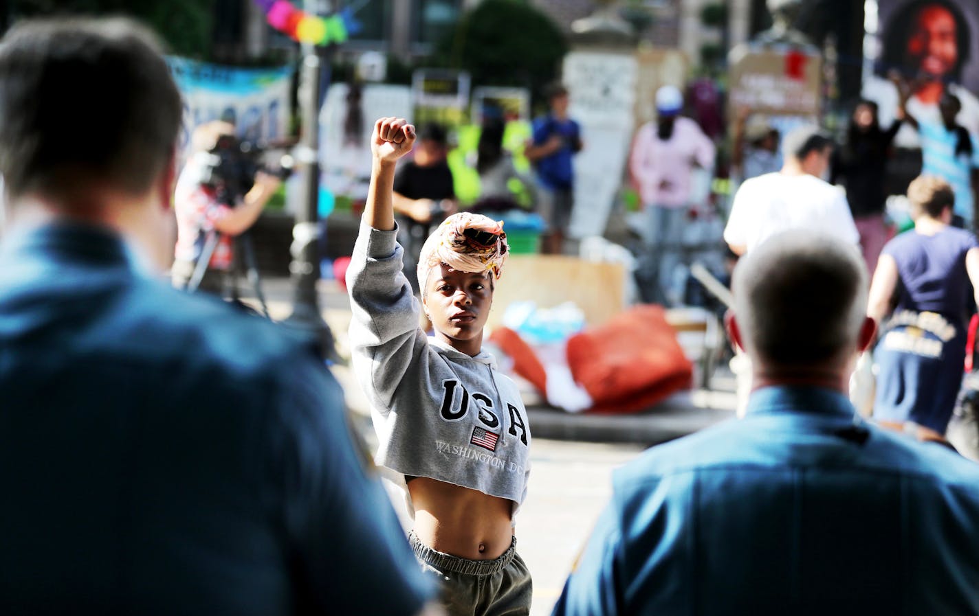 A protestor, who would not give her name, stands defiantly in front of St. Paul police Tuesday, July 26, 2016, in front of Gov. Mark Dayton's mansion in St. Paul, MN. Shortly afterwards, police moved down the block.](DAVID JOLES/STARTRIBUNE)djoles@startribune Protesters were ordered Tuesday to clear the street and sidewalk in front of the governor's residence, where they have been since the fatal police shooting of Philando Castile nearly three weeks ago in neighboring Falcon Heights.