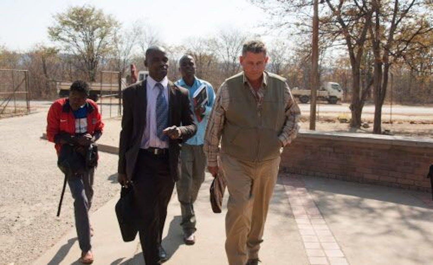 Theodro Bronkhorst, right, a professional hunter, arrives for his appearance at the magistrates courts in Hwange about 700 kilometres south west of Harare, Wednesday, July 29, 2015.