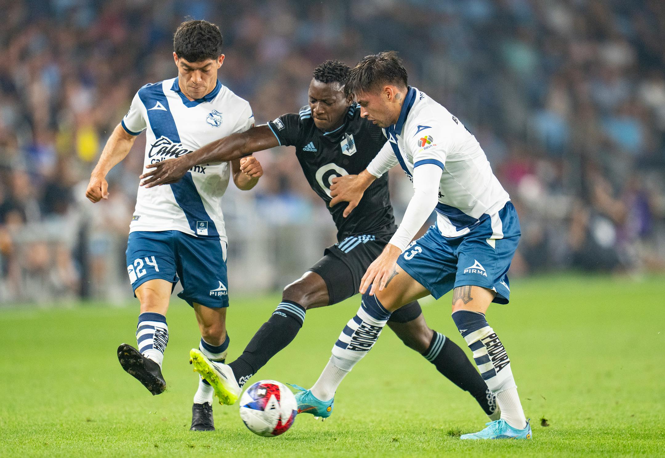 Minnesota United forward Mender García (28) attempts to maintain control of the ball while being defended by Puebla midfielder Diego Zago (24) and defender Sebastian Olmedo (3) in the second half.