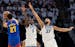 The Wolves' Anthony Edwards (5) and Rudy Gobert (27) defend the Nuggets' Jamal Murray (27) in the first quarter of Game 3 of the Western Conference se