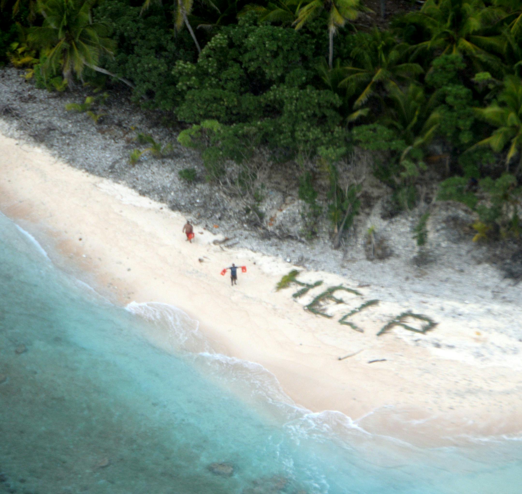 This photo provided by U.S. Navy released April 7, 2016 shows two men waving life jackets and look on as a U.S. Navy P-8A maritime surveillance aircraft discovers them on the uninhabited island of Fanadik. The three men were back to safety on Thursday, April 7, 2016, three days after going missing. (U.S. Navy/Ensign John Knight via AP)