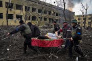 Ukrainian emergency employees and police officers evacuate injured pregnant woman Iryna Kalinina, 32, from a maternity hospital that was damaged by a 