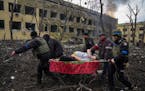 Ukrainian emergency employees and police officers evacuate injured pregnant woman Iryna Kalinina, 32, from a maternity hospital that was damaged by a 