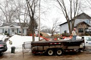 Sharon Potter (left) of Minneapolis shovels her walkway as construction has started on a teardown next to her home on the 5100 block of York. ] JOELKO