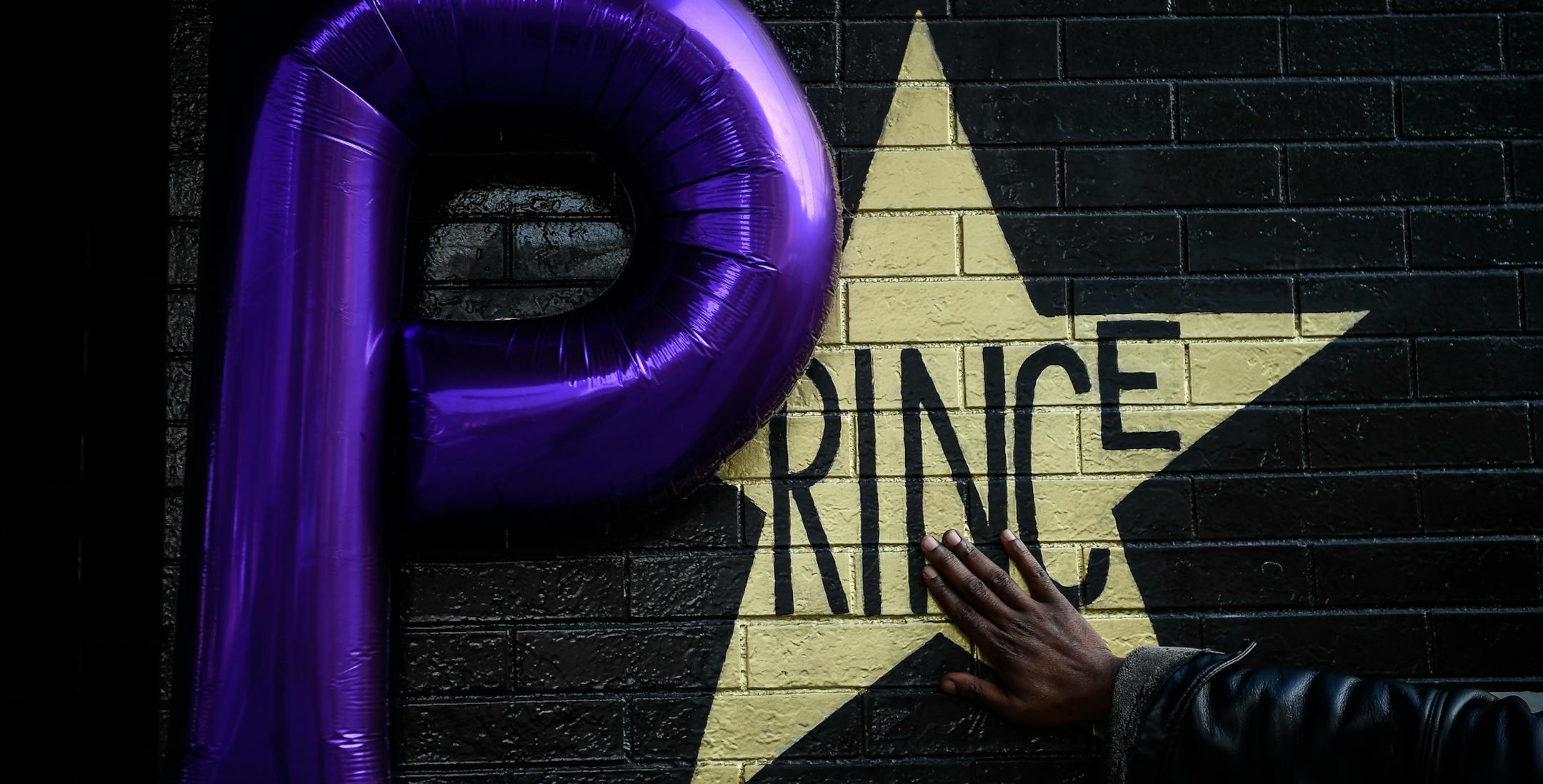 Shannon Nelson, of St. Paul, touched the Prince star on the side of First Avenue Friday afternoon. Nelson says he's a distant relative of Prince. ] AARON LAVINSKY &#xef; aaron.lavinsky@startribune.com Fans gathered outside First Avenue on the one-year anniversary of Prince's death to visit and take pictures with his store adorning the side of the building on Friday, April 21, 2017 in Minneapolis, Minn. ORG XMIT: MIN1704211958290726