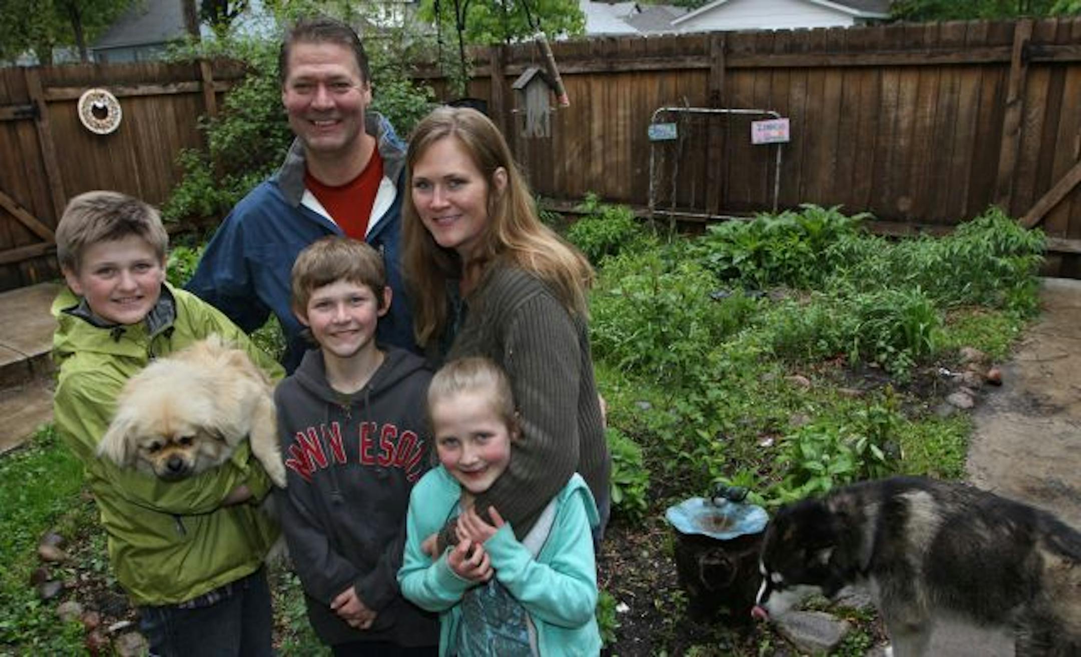 (left to right) Trace, age-12(holding Simeon the Tibetan Spaniel), Will, Rory, age-10, Kristin Berg Thompson, Dorothea, age-8 and Happy Trails (the Malamute) were photographed in the family butterfly and flower garden. The garden is yet to bloom.