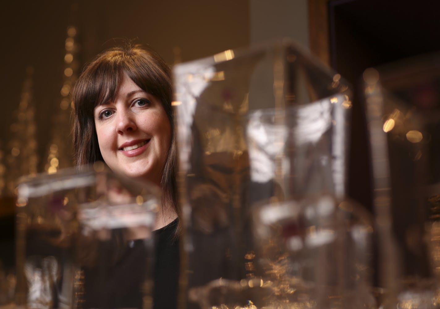 Carly Winslow of Ampersand Shops in the Galleria in Edina, with Simon Pearce glassware.