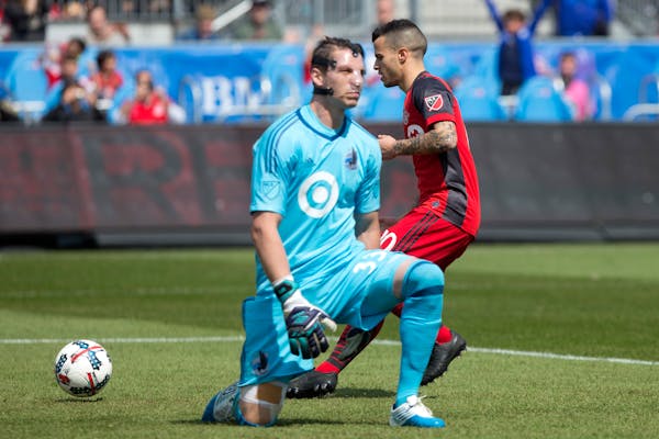 Toronto FC's Sebastian Giovinco, rear, collects the ball after slotting a penalty past Minnesota United goalkeeper Bobby Shuttleworth during the first