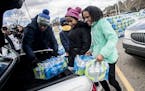 Mari Copeny, also known as Little Miss Flint, and her cousin Ivory Moon load vehicles with cases of free bottled water during World Water Day on Frida