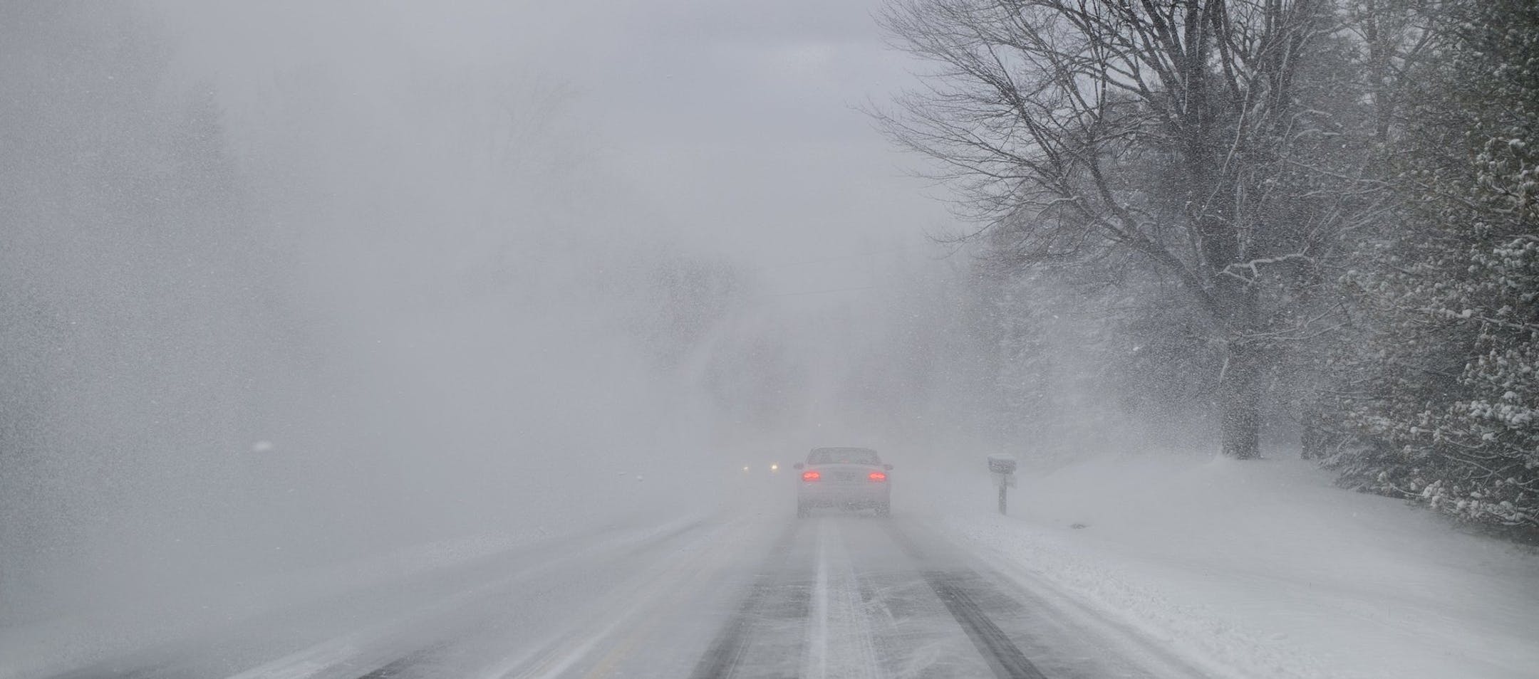 A car navigates near white-out conditions on Pine Island Drive as people try to find alternate routes to US-131 after a pileup there on Friday, Dec. 18, 2015. Slick road conditions were blamed on lake effect snow. (Neil Blake/Grand Rapids Press-MLive.com via AP)