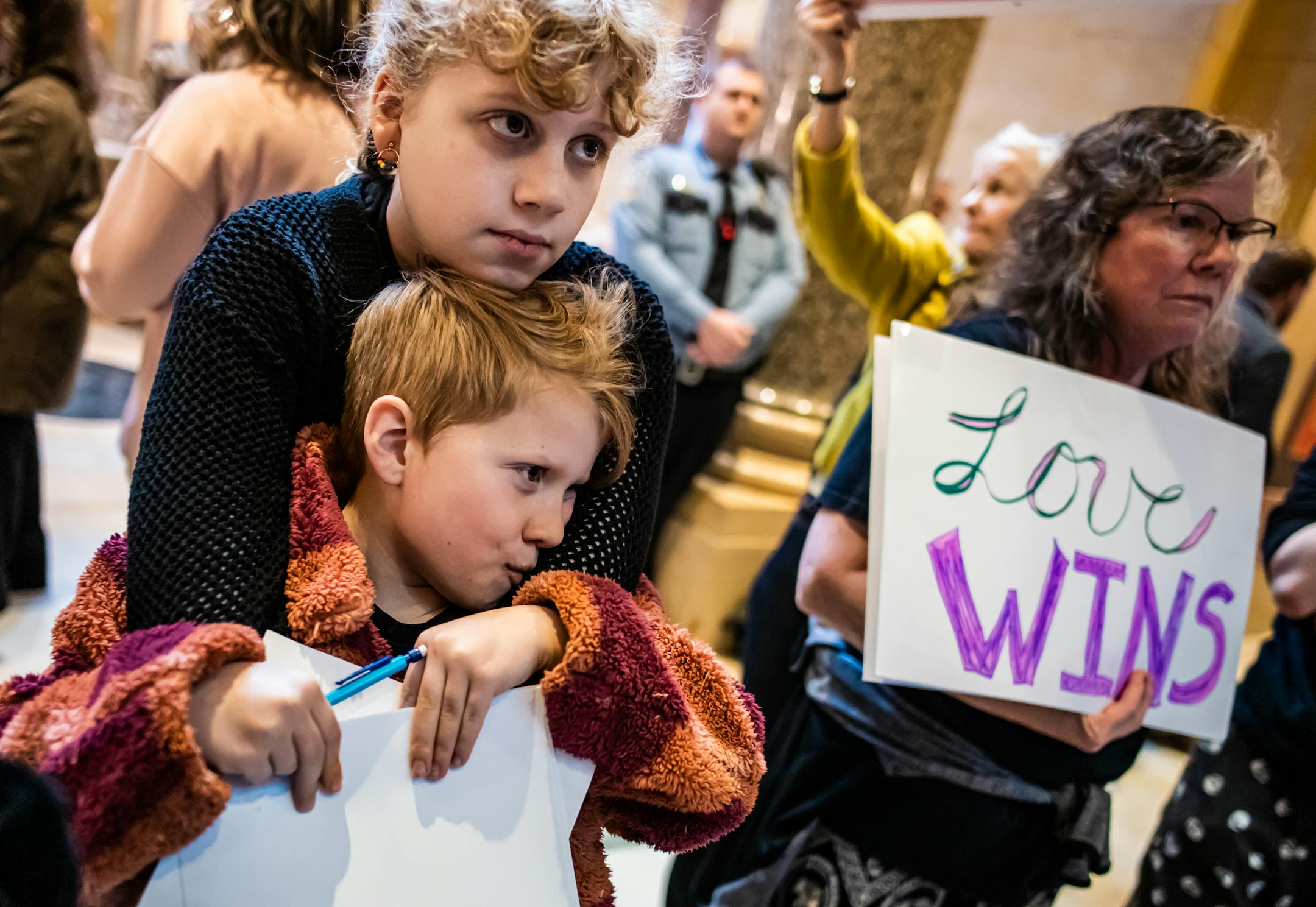 Hildie Edwards with sister Dahlia take time from school to advocate for the "trans refuge" bill up for vote in the Senate at the Capitol in St. Paul, Minn., on Friday, April 21, 2023. In the background are signs opposing and supporting the issue. Hildie Edwards is a transgender activist who has helped pass legislation making Minnesota a refuge for transgender individuals. ] RICHARD TSONG-TAATARII • richard.tsong-taatarii@startribune.com