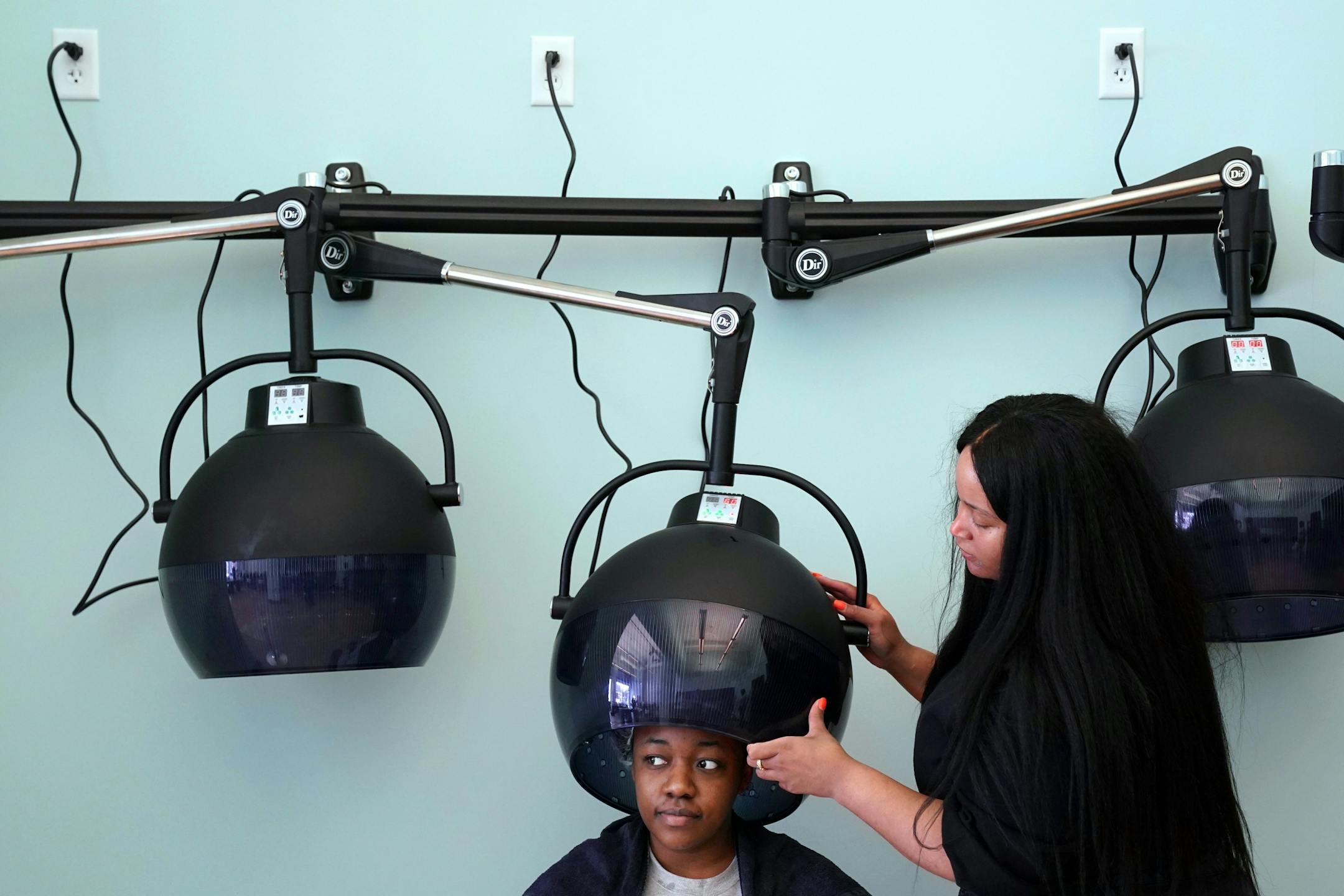 Sasha Dennis of Minneapolis sat under a dryer after getting her hair washed by stylist Andrewa Murphy, right, Wednesday morning at the Beauty Lounge.