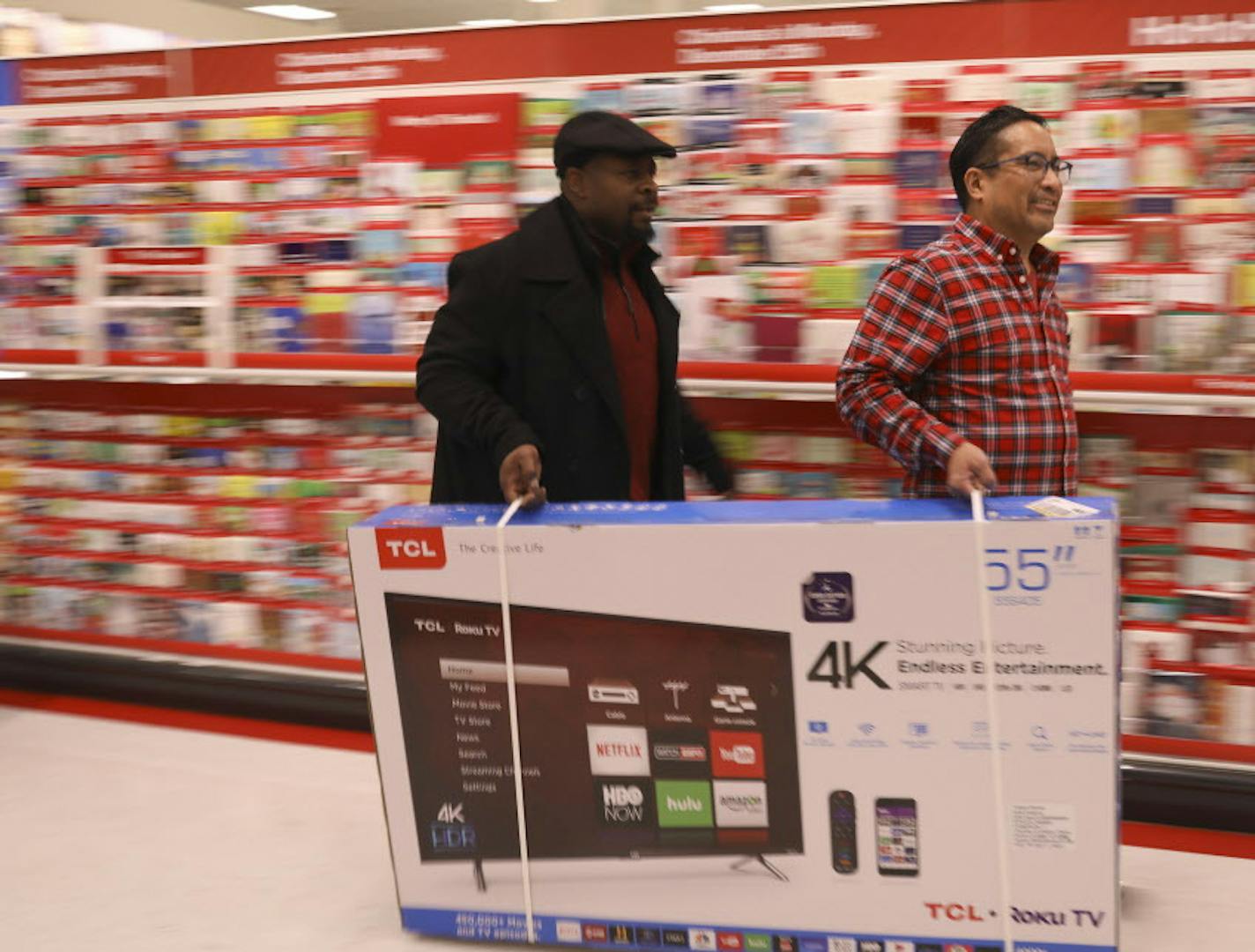 Erick Moore, left, helped Richard Nicolas carry a 55" flat screen television to the checkout area Thursday evening at the Target in Ridgedale. ] JEFF WHEELER &#xef; jeff.wheeler@startribune.com The Target Ridgedale location opened it's doors at 6 p.m. for early Black Friday shopping Thanksgiving evening, November 23, 2017 in Minnetonka.