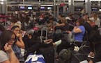 Passengers in the Delta Airlines boarding area at McCarran International Airport in Las Vegas are jammed in to wait as Delta Airlines says all its fli
