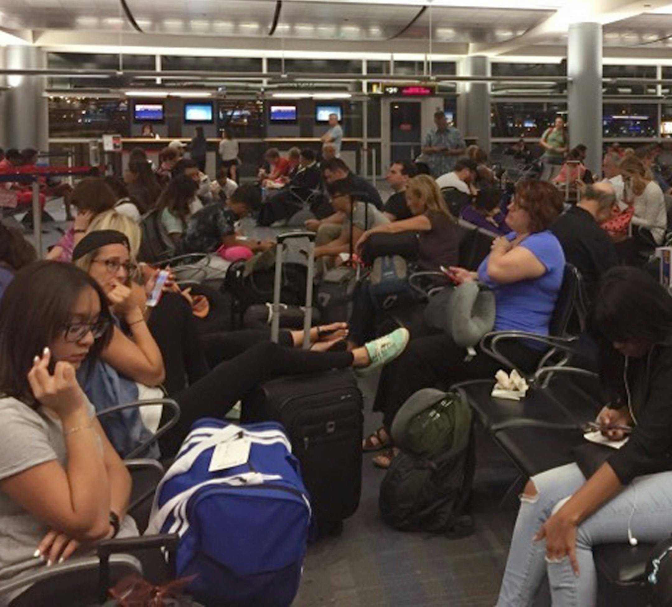 Passengers in the Delta Airlines boarding area at McCarran International Airport in Las Vegas are jammed in to wait as Delta Airlines says all its flights are grounded due to a system outage, Monday, Aug. 8, 2016. Delta Air Lines says it is has grounded flights after experiencing unspecified systems issues. (AP Photo/Bree Fowler)