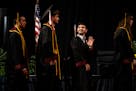 Justin Pascua waves to his family before walking in the University of Minnesota’s College of Liberal Arts graduation ceremony Sunday in Minneapolis.