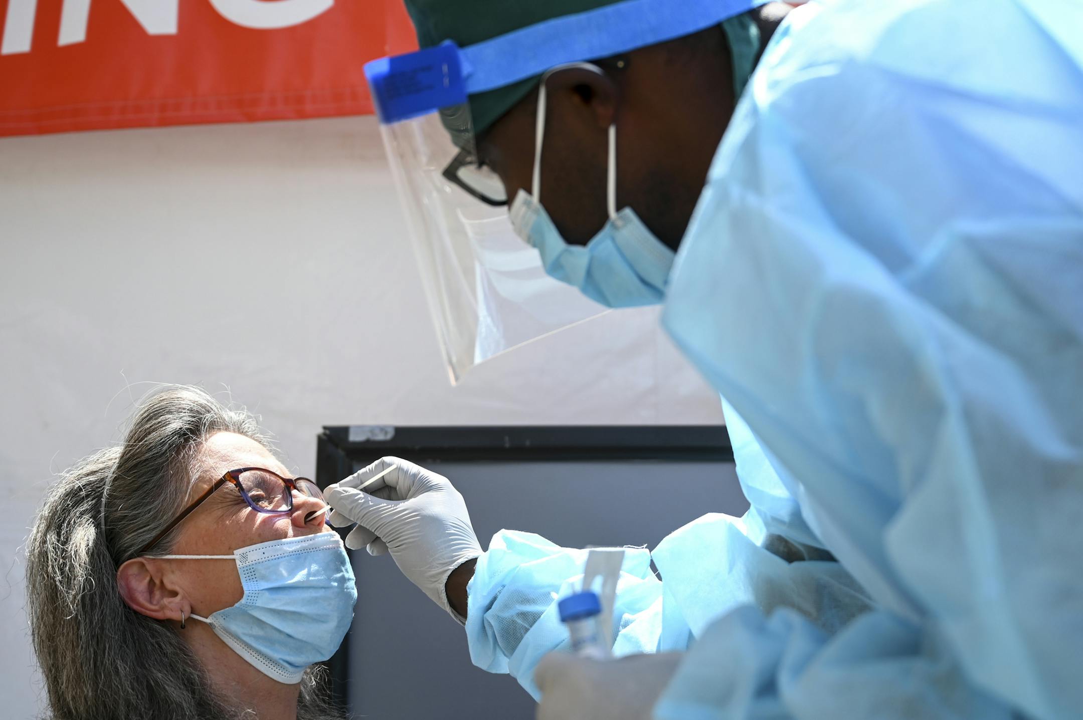 Finn Marube, a clinical scientist with North Memorial, administered a COVID-19 test to Sandra Lynn White, of Minneapolis, in Robbinsdale in July.