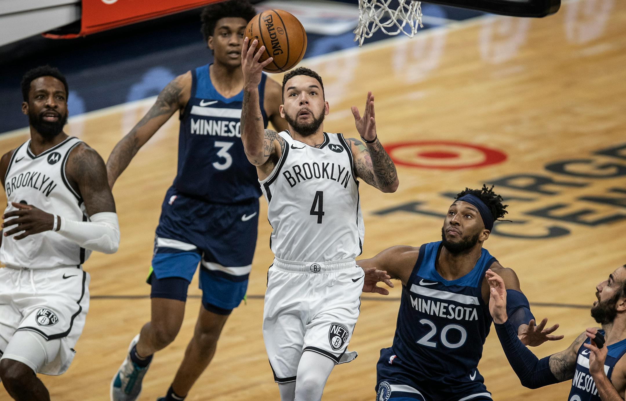 Brooklyn Nets guard Chris Chiozza (4) scored over Minnesota Timberwolves forward Josh Okogie (20) at Target Center on April 13, 2021 in Minneapolis.