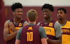 Gophers forward Eric Curry (24) and center Daniel Oturu (25) joked with guard Brady Rudrud (10) during Thursday's practice.