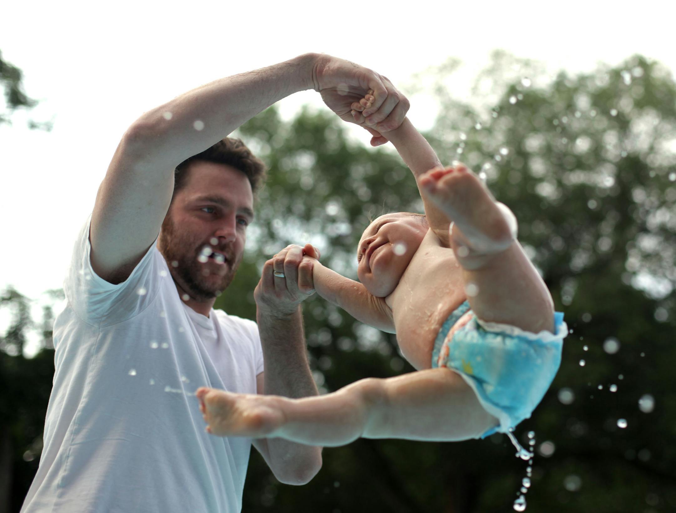 Christian Murphy and his son Waylon,1, cool off in the wading pool at Powderhorn Park on Monday morning.