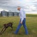 Dr. Bowman walked to check on a corral of newly arrived horses as his dog Jade, a German short-haired pointer, frolicked around him at his ranch in No