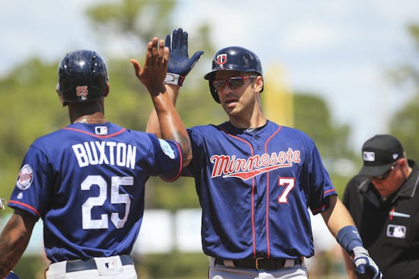Minnesota Twins' Byron Buxton (25) high-fives Joe Mauer after his two run home run in the fourth inning against the Tampa Bay Rays during a spring tra