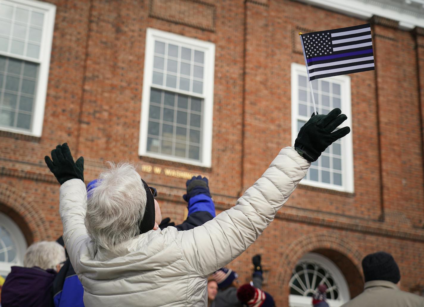 Mary Hamilton held up a flag in support of police at the "Pray America Great" event in Fergus Falls, Minn., in October.