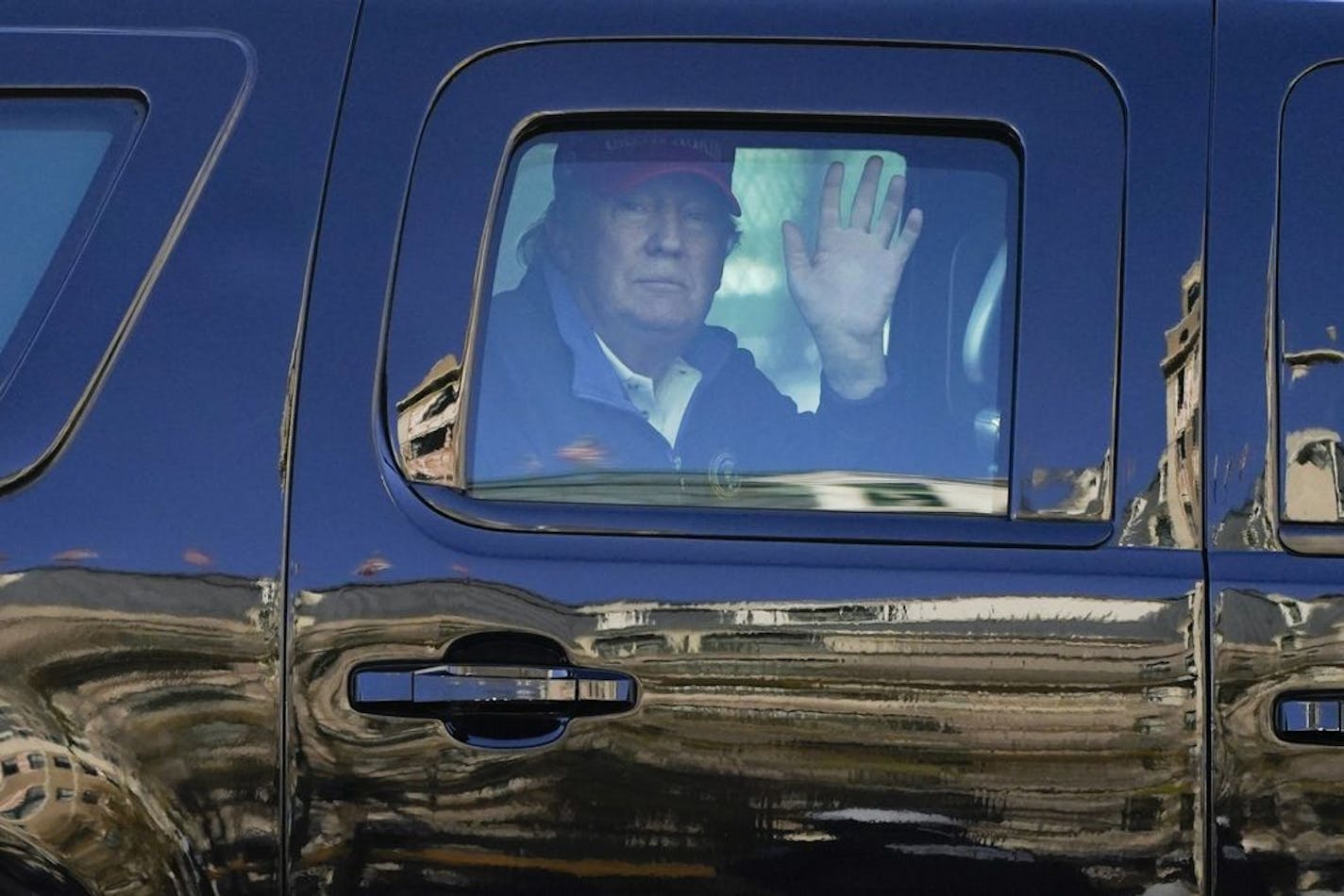 President Donald Trump waves to supporters from his motorcade as people gather for a march Saturday, Nov. 14, 2020, in Washington.