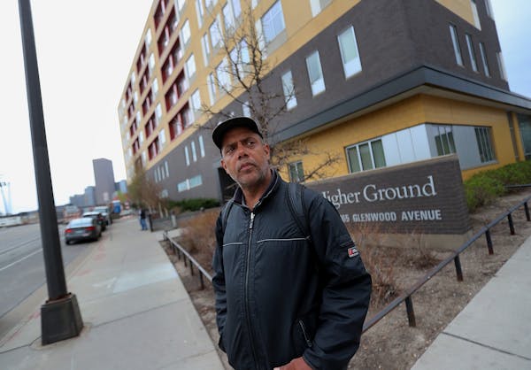 After moving out of the Higher Ground homeless shelter in Minneapolis Douglas Pyle, 49, looks down the street for a bus that will take him to his hote