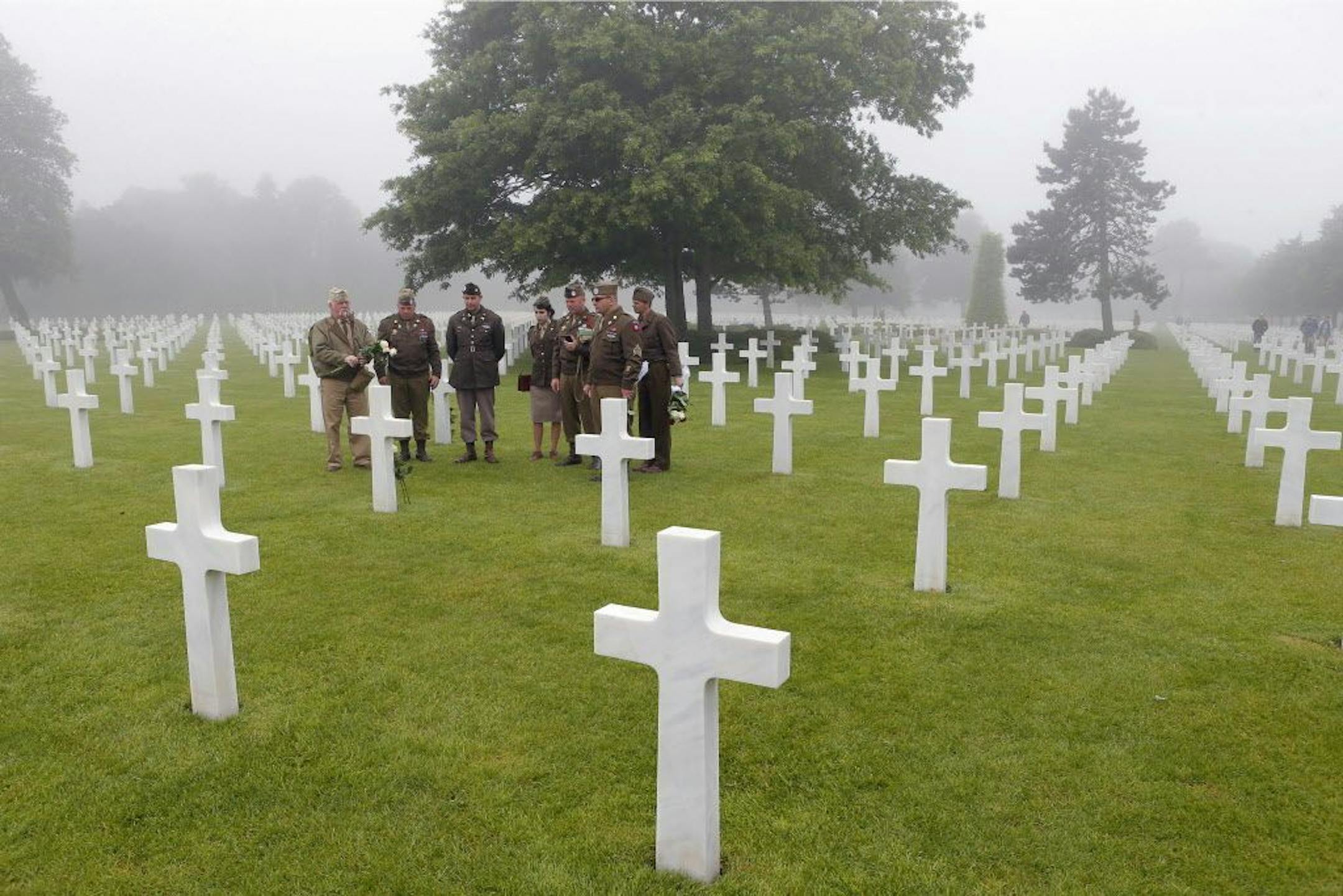 French members of WWII veteran association "Les Fleurs de la Memoire", Flowers for Memory, pay their respects in front of the tomb of Morris H. Hilghman Jr of the PVT 507 Parachute Inf Regiment from west Virginia , who died on June 9, 1944, in the Colleville American military cemetery, in Colleville sur Mer, western France, Monday June 6, 2016, on the 72nd anniversary of the D-Day landing. D-Day marked the start of a Europe invasion, as many thousands of Allied troops began landing on the beache