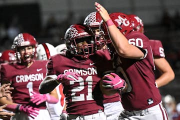 Maple Grove running back Charles Langama (21) and center Rylan Bahl (60) celebrate a touchdown by Langama in the second half against Centennial Thursd