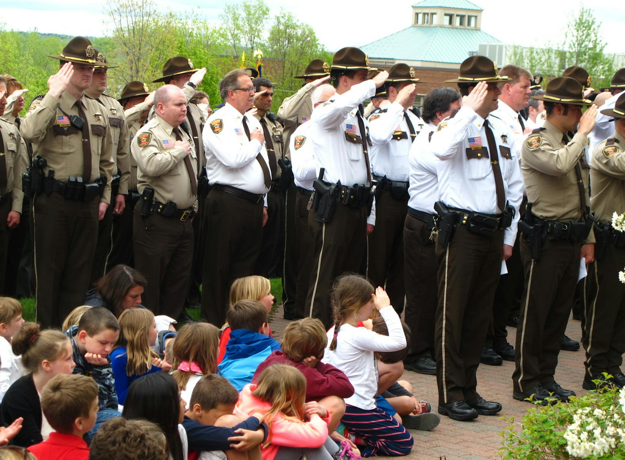 A Rutherford Elementary School student joins sheriff deputies and corrections officers in a salute to remember to remember fallen peace officers May 15 at Historic Courthouse.