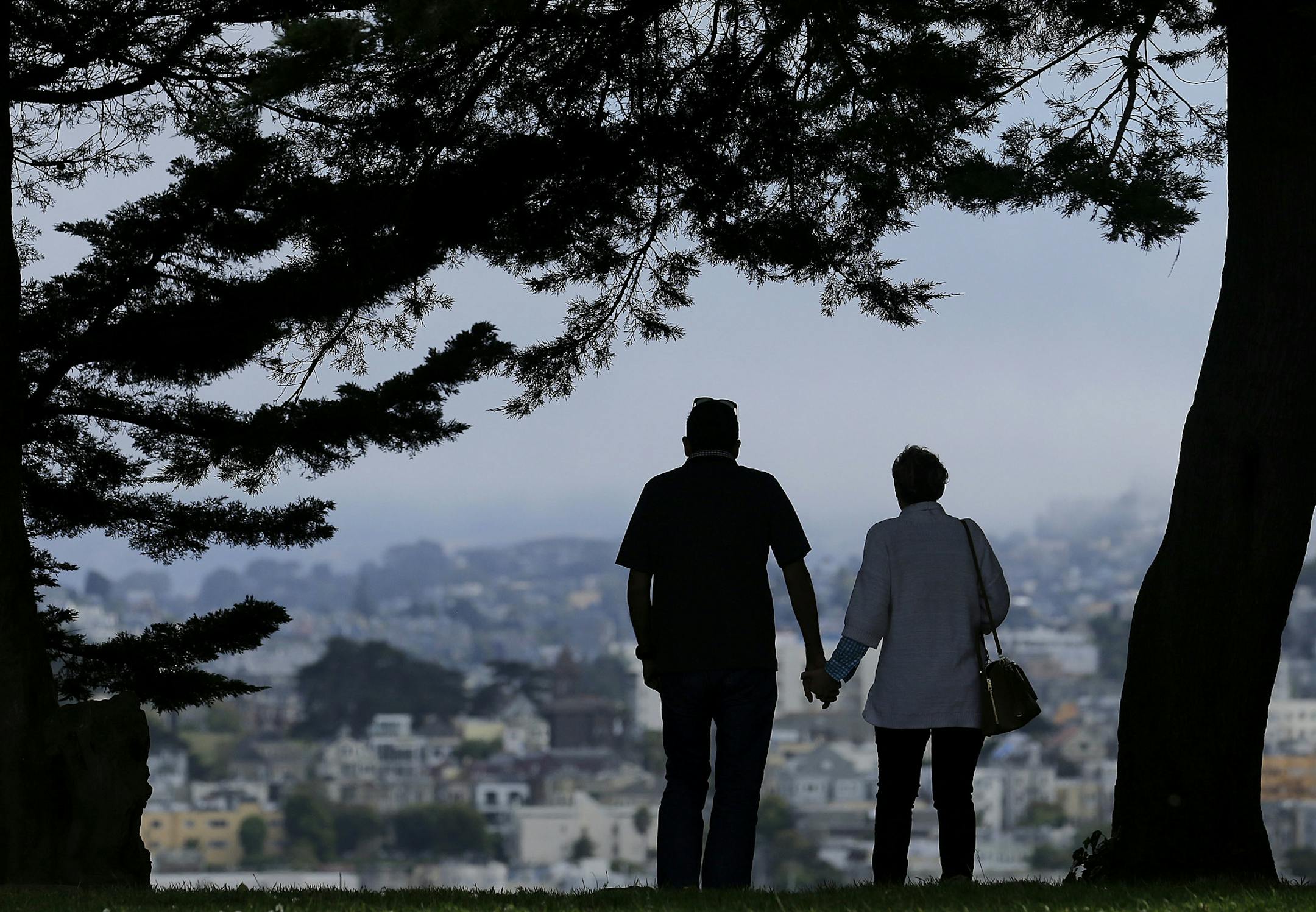 FILE- In this July 3, 2017, file photo a man and woman walk under trees down a path at Alta Plaza Park in San Francisco. Looking at the income, living expenses and life spans of today&#x2019;s retirees can help you make the right financial moves so your golden years aren&#x2019;t tarnished by an unexpected shortfall. (AP Photo/Jeff Chiu, File)