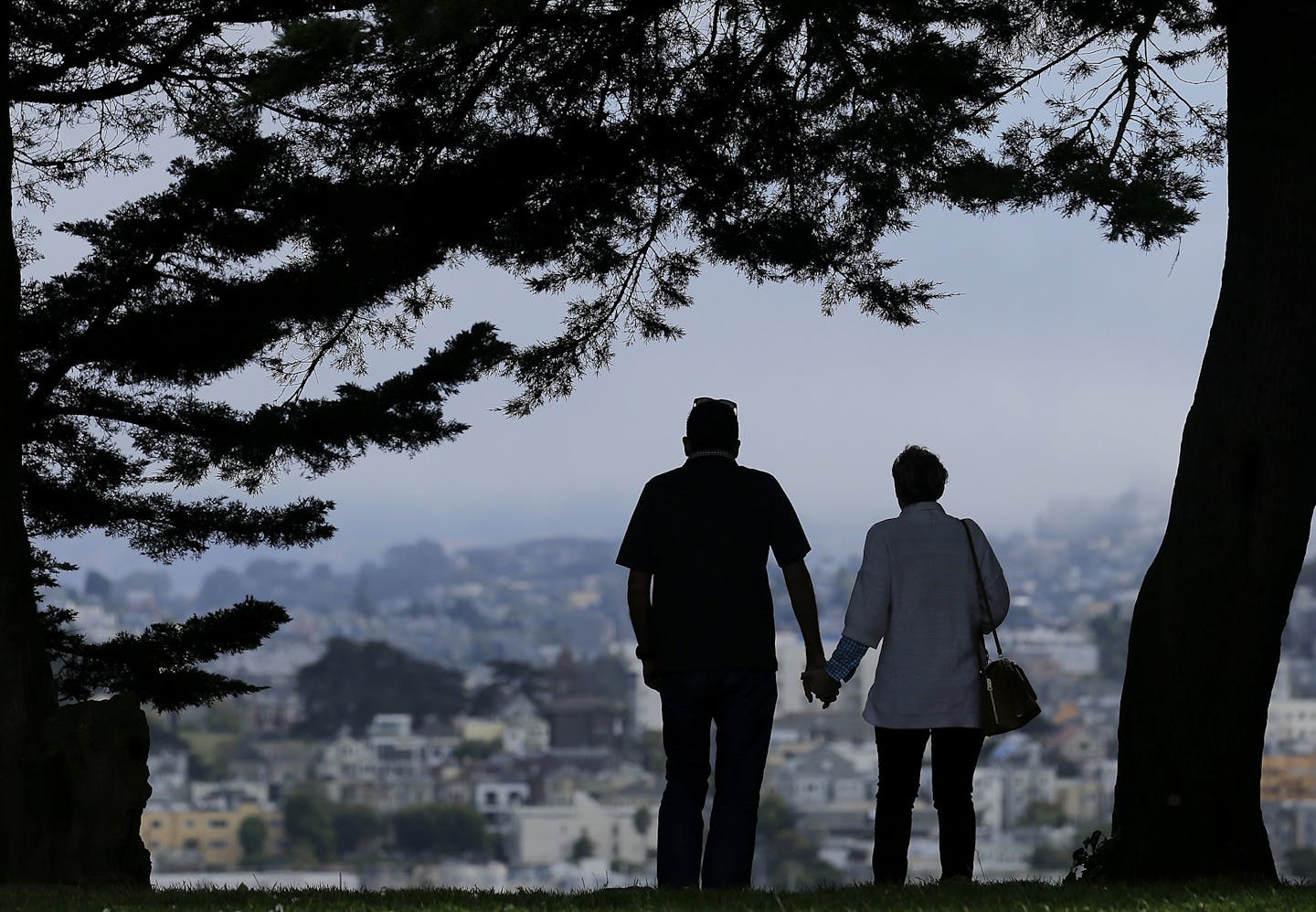 FILE- In this July 3, 2017, file photo a man and woman walk under trees down a path at Alta Plaza Park in San Francisco. Looking at the income, living expenses and life spans of today&#x2019;s retirees can help you make the right financial moves so your golden years aren&#x2019;t tarnished by an unexpected shortfall. (AP Photo/Jeff Chiu, File)