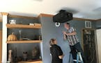 Finishing touches on the installation of a professional grade ceiling-mounted projector. (Handout/TNS)
