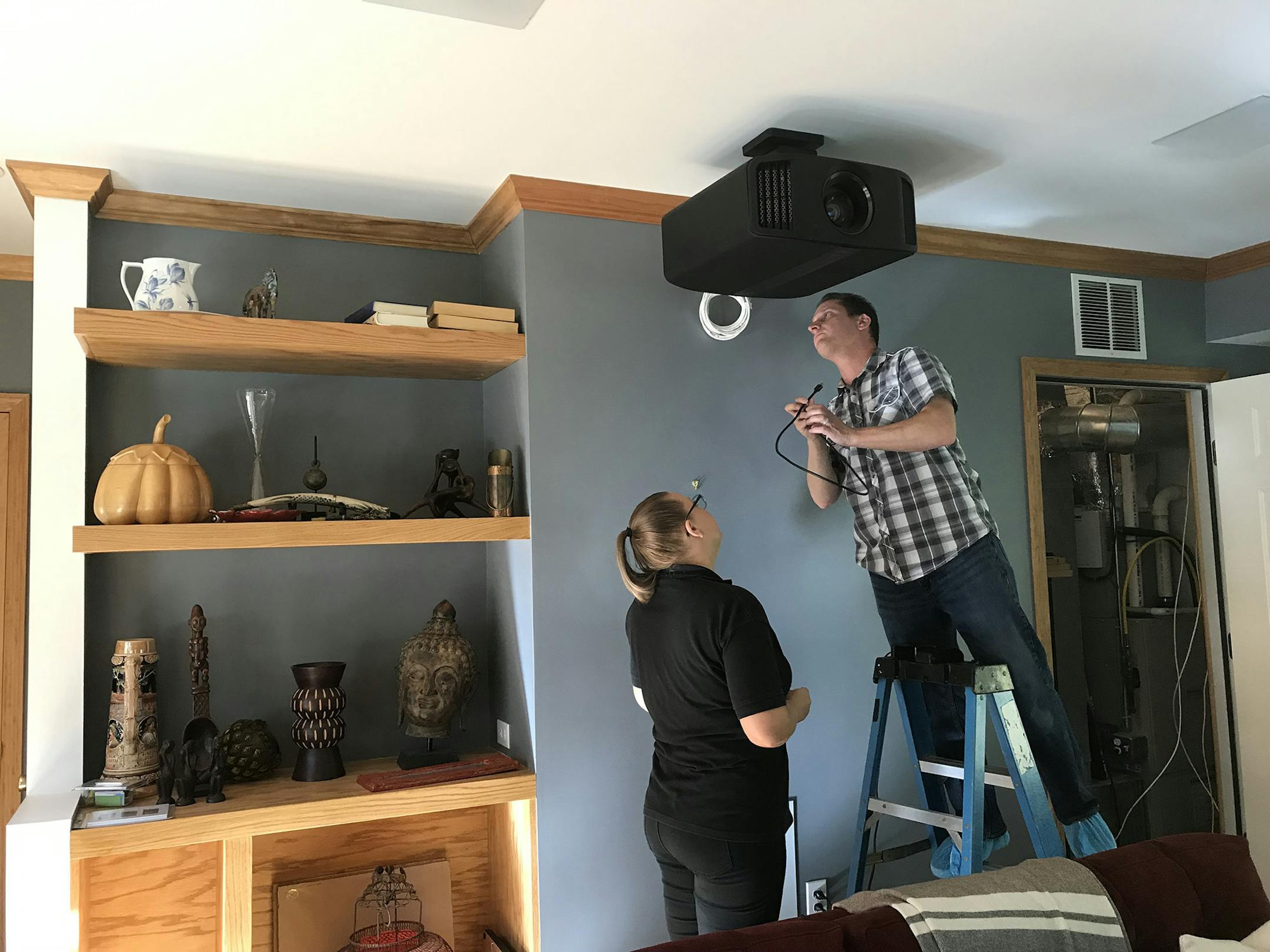 Finishing touches on the installation of a professional grade ceiling-mounted projector. (Handout/TNS)