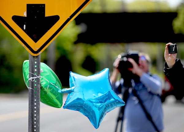 Balloons hang on a sign near the scene where a child was struck by a school bus at Maryland Ave. and Dale St. and is now in critical condition Thursda