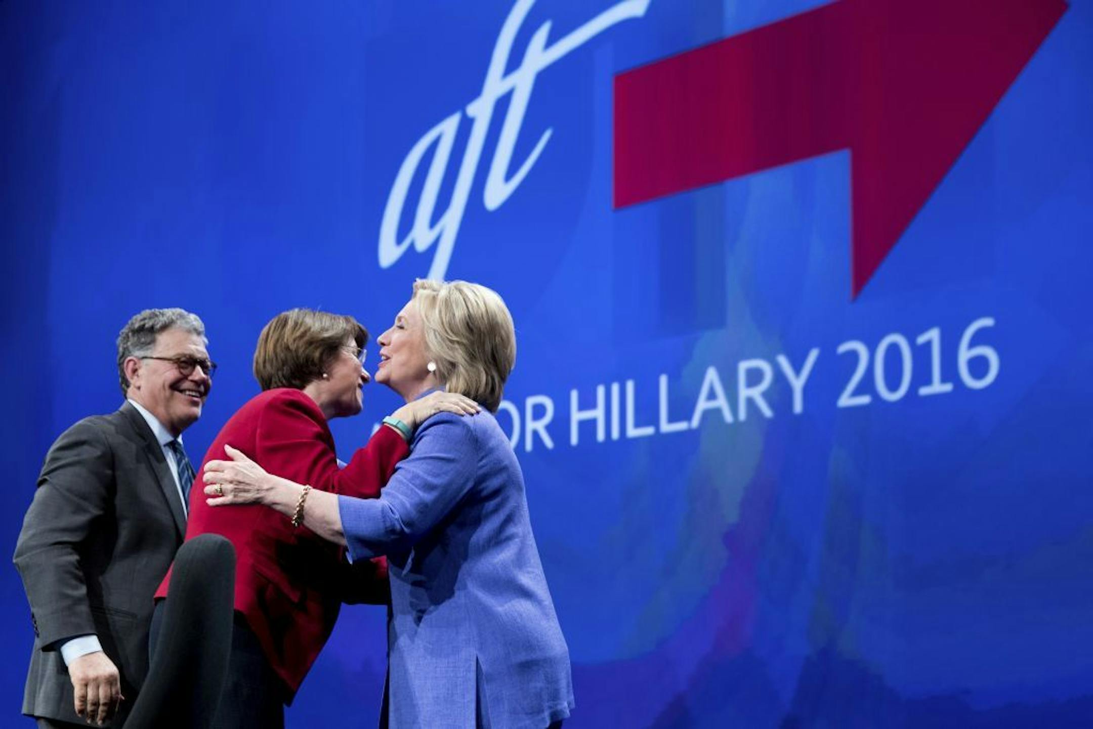 Democratic presidential candidate Hillary Clinton, is greeted by Sen. Al Franken, D-Minn., left, and Sen. Amy Klobuchar, D-Minn., second from left, as she arrives to speak at the American Federation of Teachers convention at the Minneapolis Convention Center in Minneapolis, Monday, July 18, 2016.