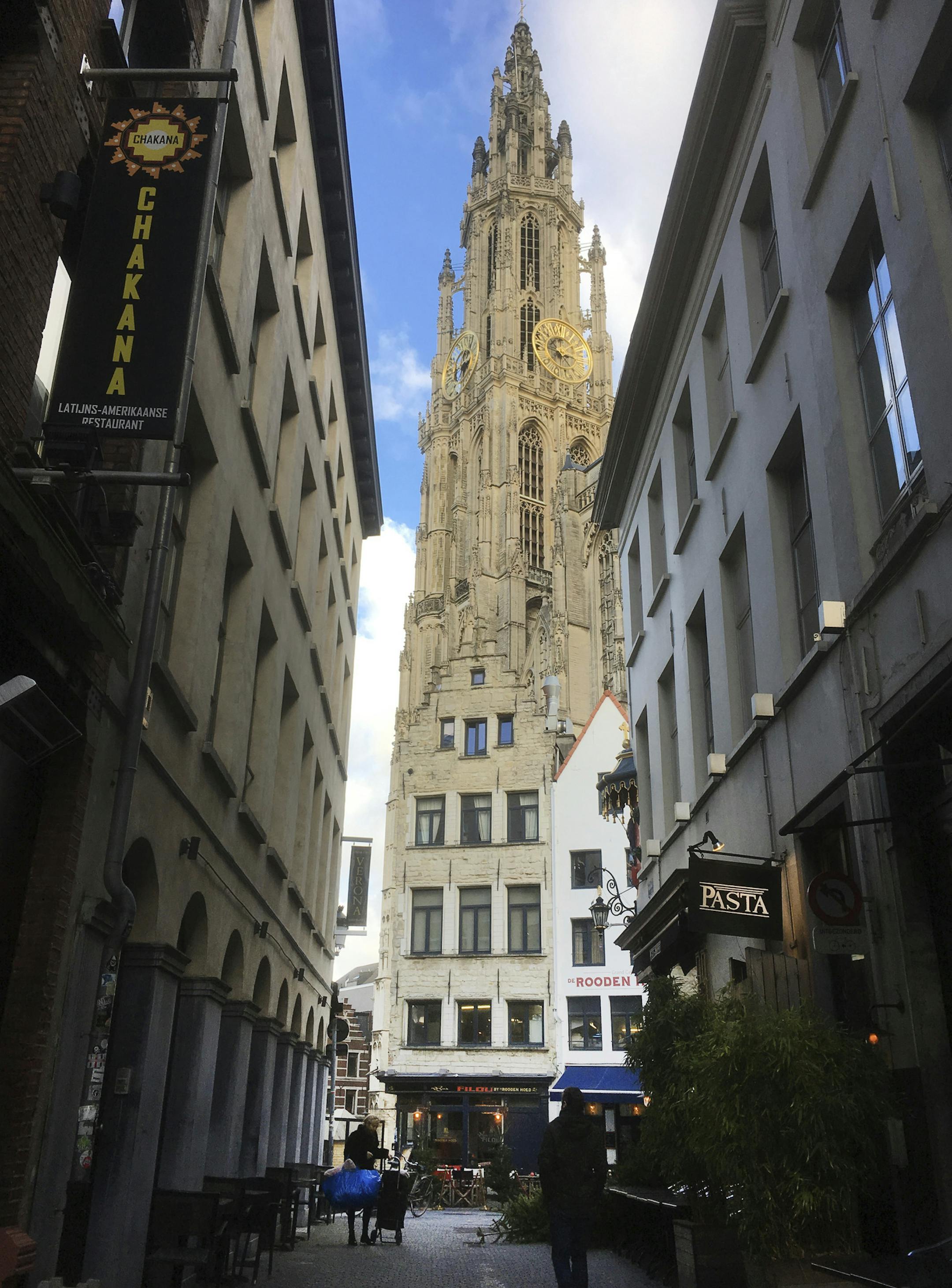 Two people walk in an alley way near the Cathedral of Our Lady in Antwerp, Belgium, Wednesday, Jan. 9, 2019. The church itself contains a number of works by the Baroque painter Peter Paul Rubens. (AP Photo/Virginia Mayo)