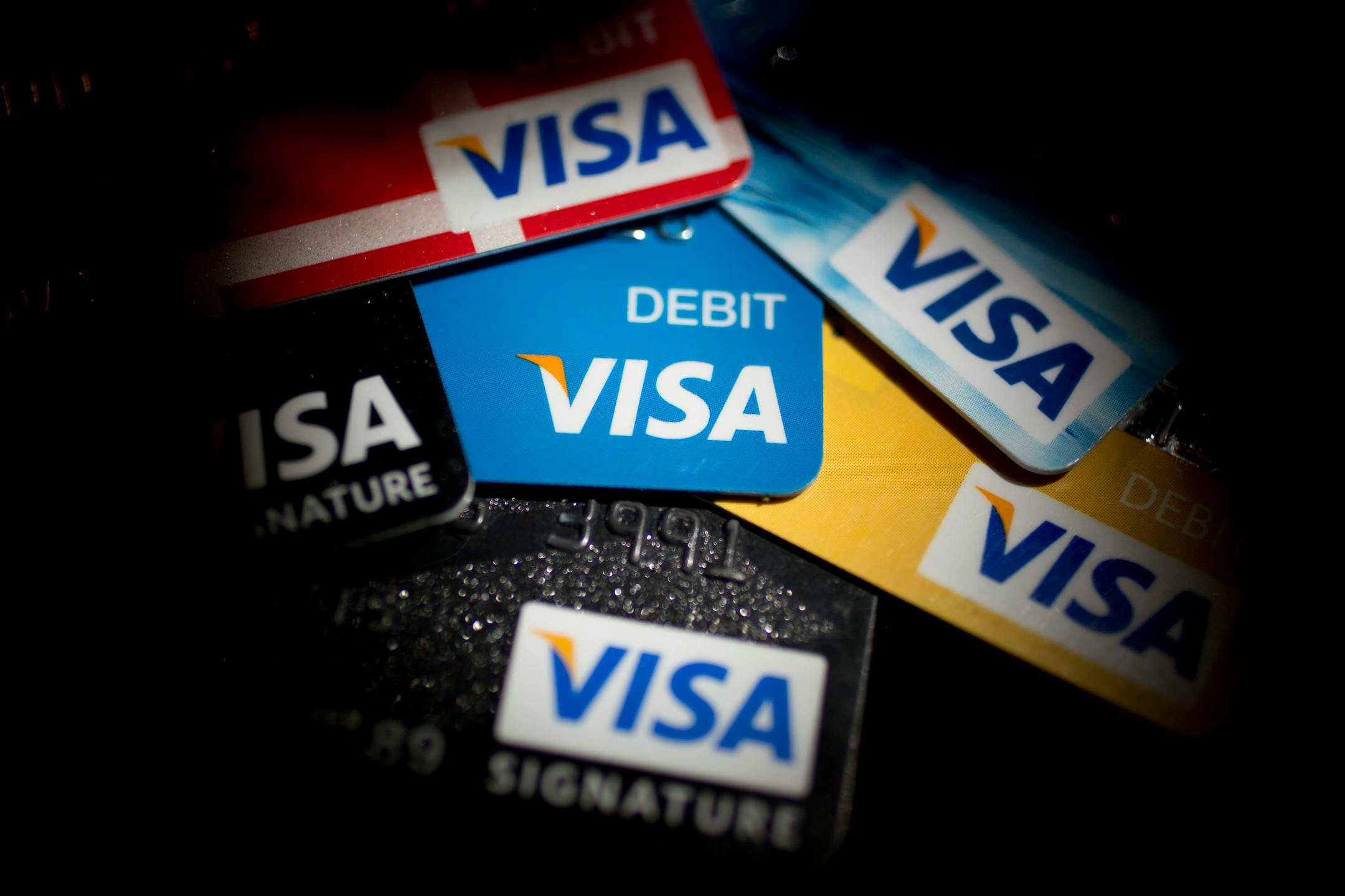 Visa Inc. credit and debit cards are arranged for a photograph in Washington, D.C., U.S., on Wednesday, Jan. 29, 2014. Visa Inc. is expected to release earnings data on Jan. 30. Photographer: Andrew Harrer/Bloomberg