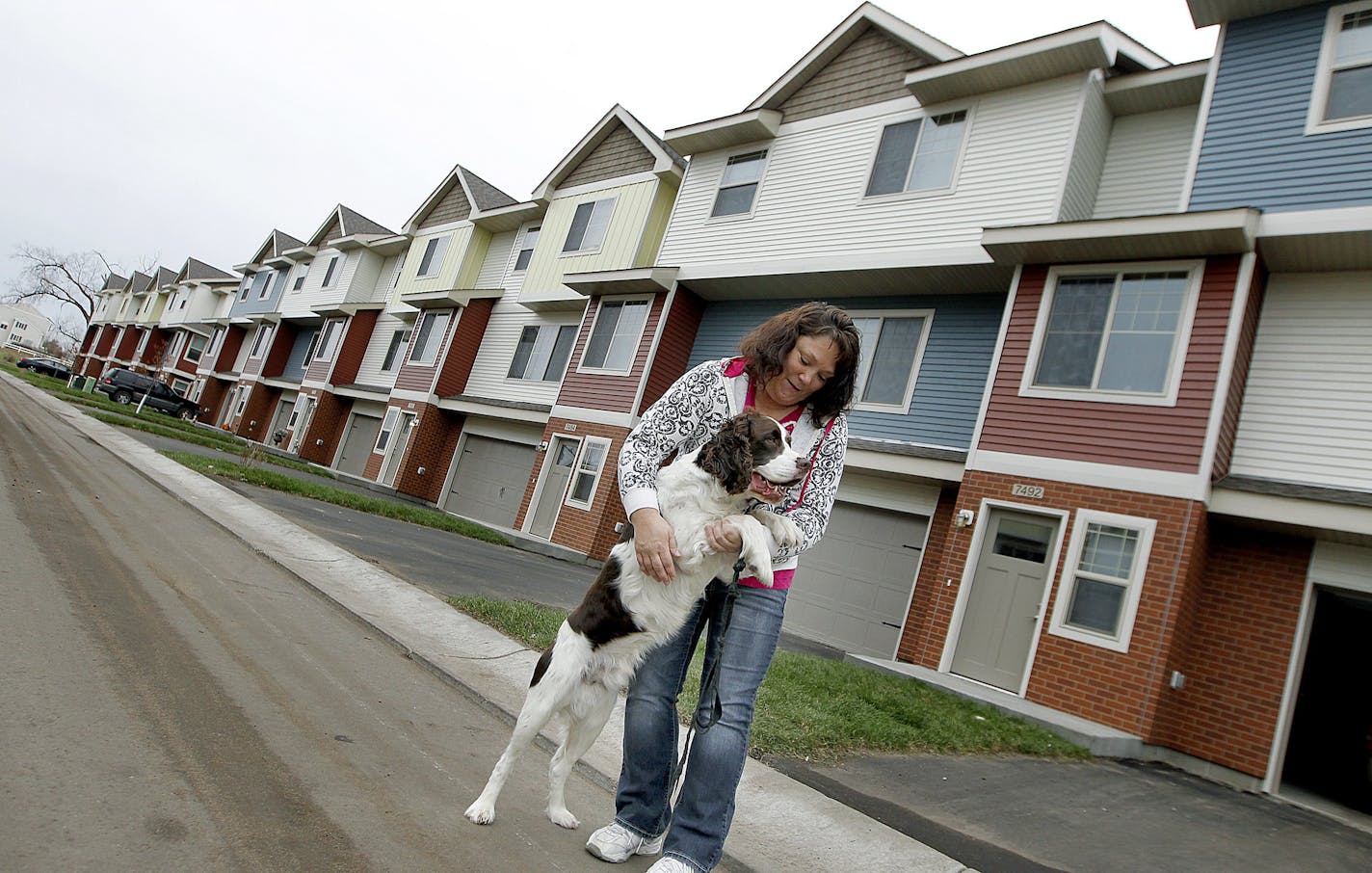 Kris Thuhl played with her dog "Max" outside the new home she just moved her family into, Thursday, November 14, 2013 in Ramsey, MN. UnitedHealth is investing $50 million in Minnesota to build affordable housing units. Their home, is in the Seasons Townhomes, a 50-unit complex in Ramsey that is part of a $100 million nationwide investment. (ELIZABETH FLORES/STAR TRIBUNE) ELIZABETH FLORES &#x2022; eflores@startribune.com