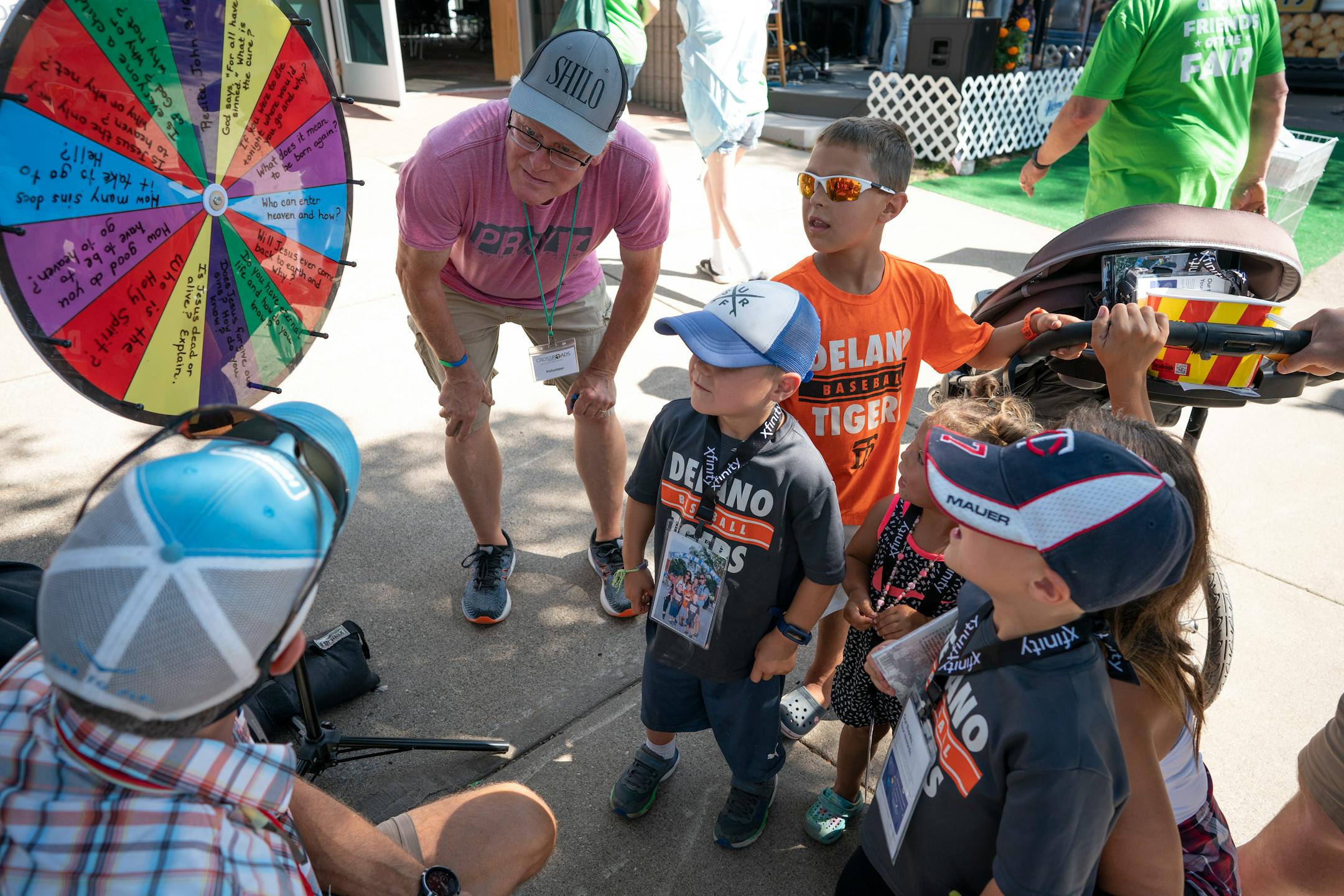 Crossroads Chapel volunteers John Colby, left, and Jerry Rosamond read biblical questions on a "spin the wheel" game to members of the Baldwin family.