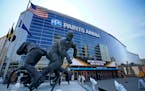 A statue of Pittsburgh Penguins Hockey Hall of Fame center Mario Lemieux, left, stands in front of the PPG Paints Arena, the site of the 2021 NCAA Men